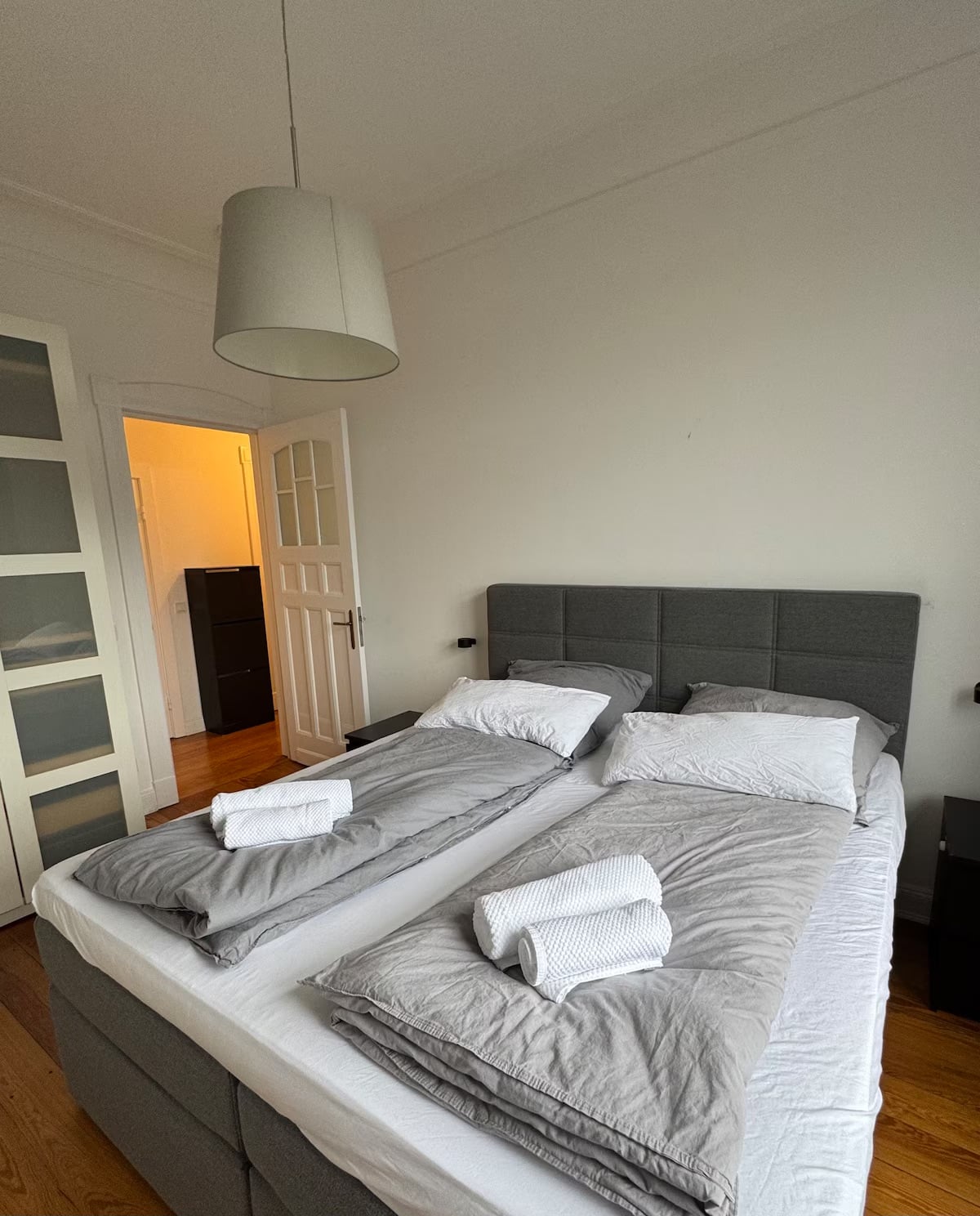 Schlafzimmer mit Boxspringbett und Handtüchern