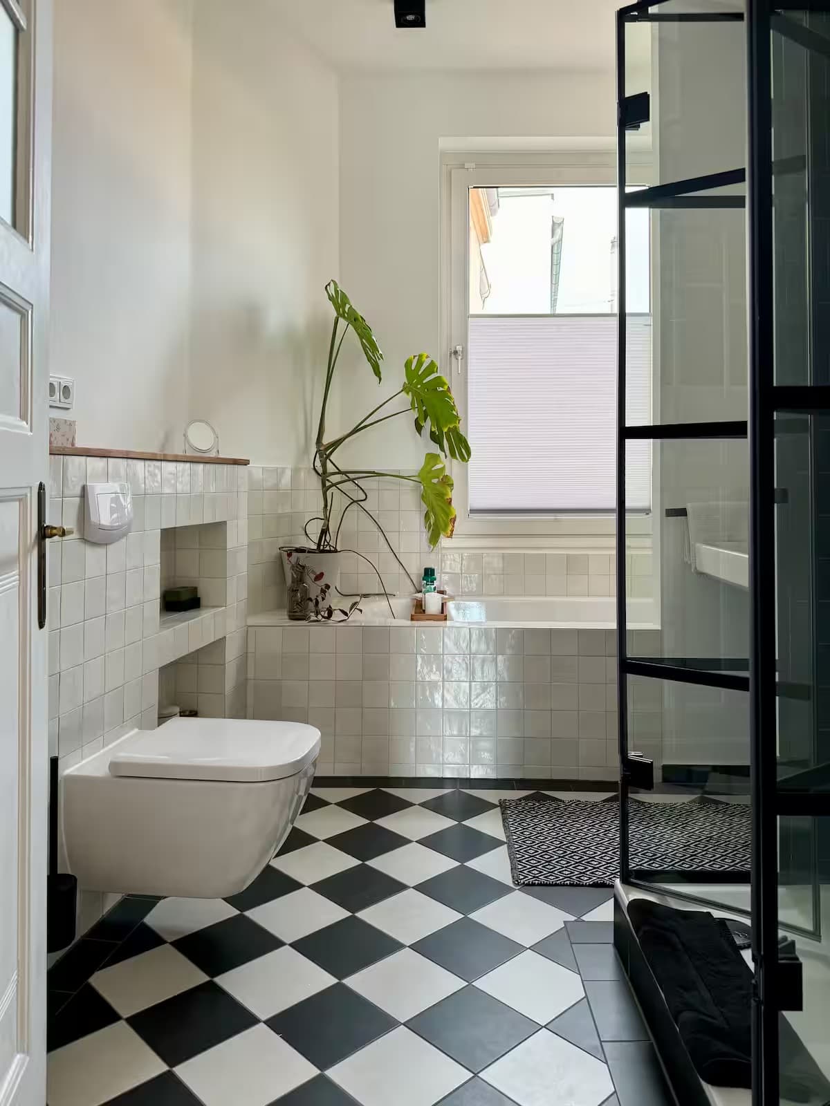 Badezimmer mit schwarz-weißem Schachbrettboden